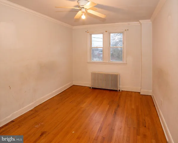 a view of a room with wooden floor and a hallway