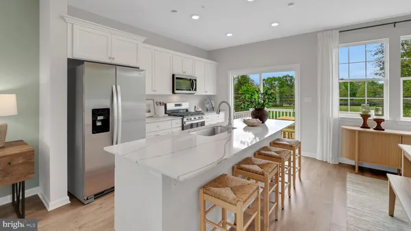 a view of living room with stainless steel appliances furniture large window and wooden floor