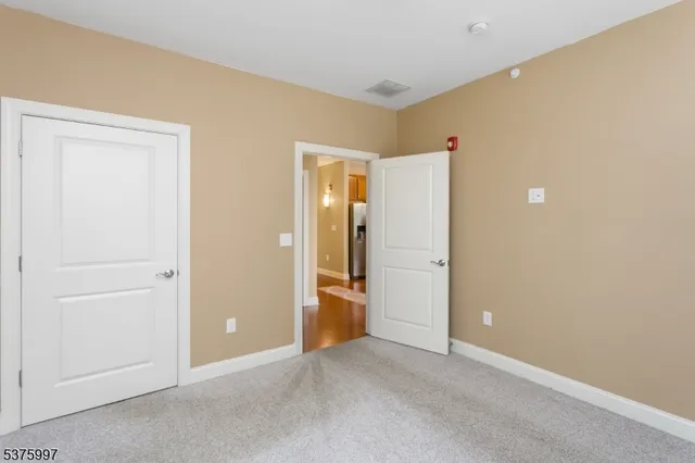an empty room with closet and wooden door