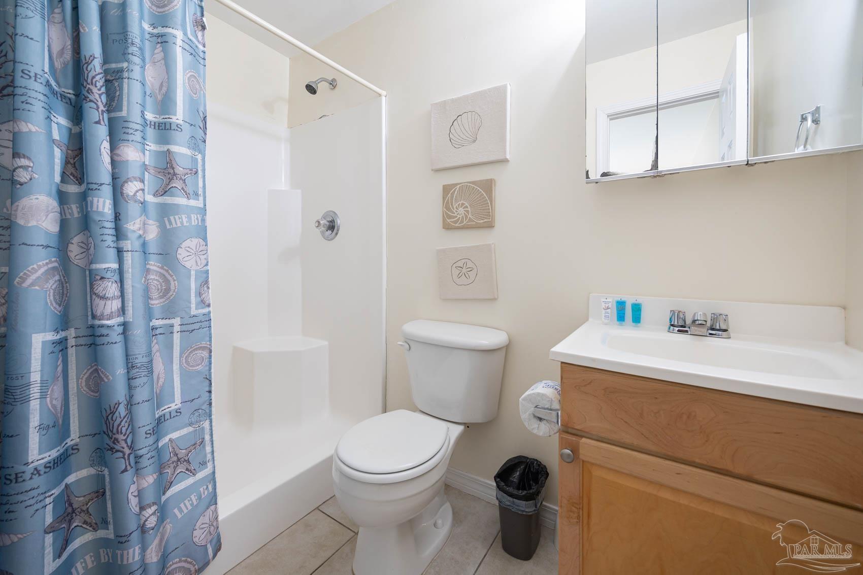 16470 Perdido Key Drive, Unit B13 Perdido Key, FL 32507 - Photo 15 of 17 a bathroom with a sink a toilet a shower and a mirror