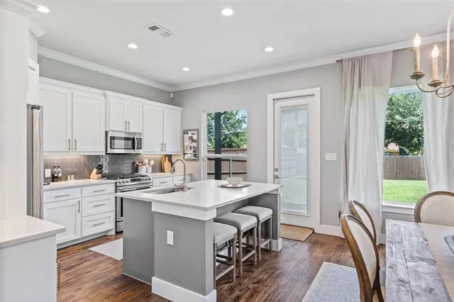 a kitchen with a table chairs stove and cabinets
