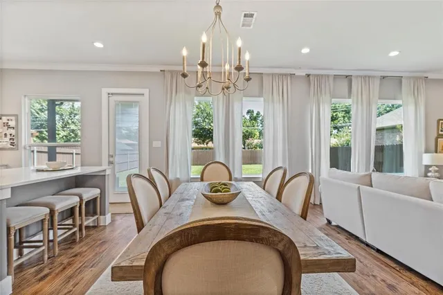 a view of a dining room with furniture wooden floor and chandelier