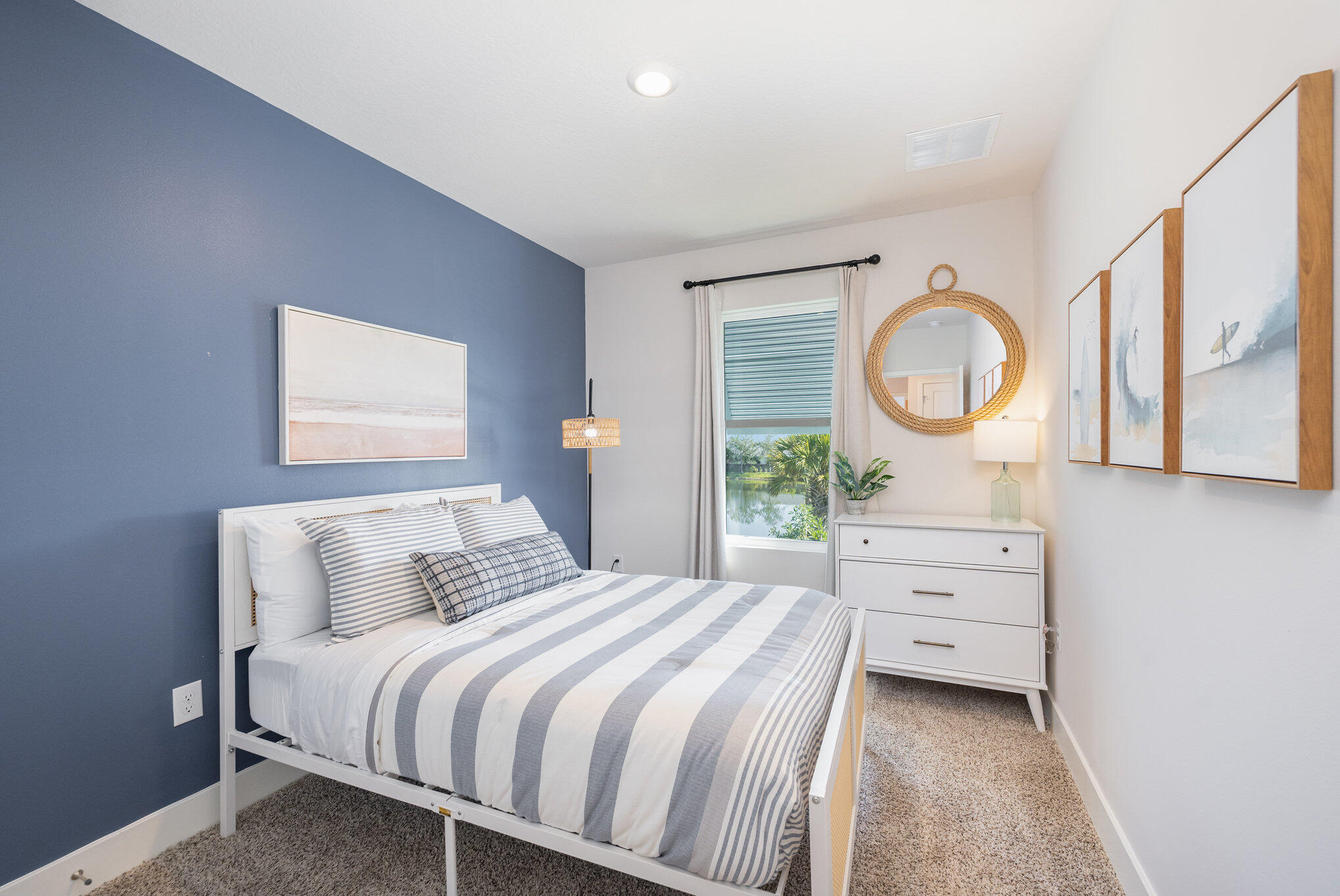 8160 Cobblestone Drive Fort Pierce, FL 34945 - Photo 16 of 17 a bedroom with a bed a mirror and a window