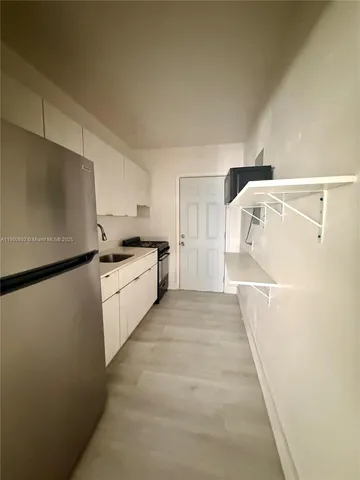 a view of a kitchen with white cabinets