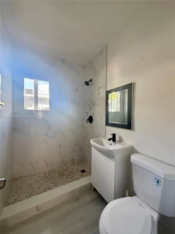 a bathroom with a sink mirror toilet and shower