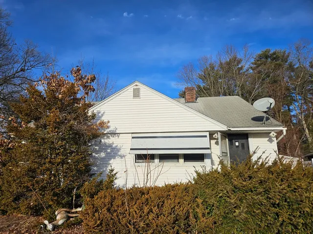 a view of a house with a yard and potted plants