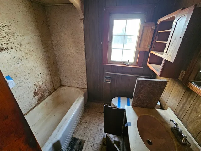 a bathroom with a tub toilet and sink