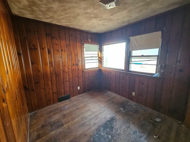 an empty room with windows cabinet and front door