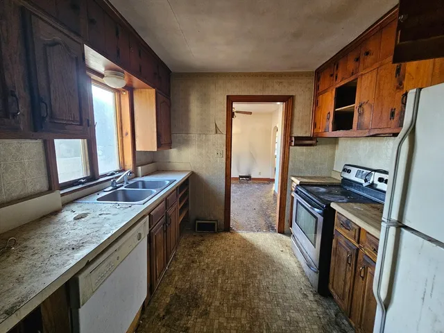 a kitchen with stainless steel appliances granite countertop sink stove and refrigerator