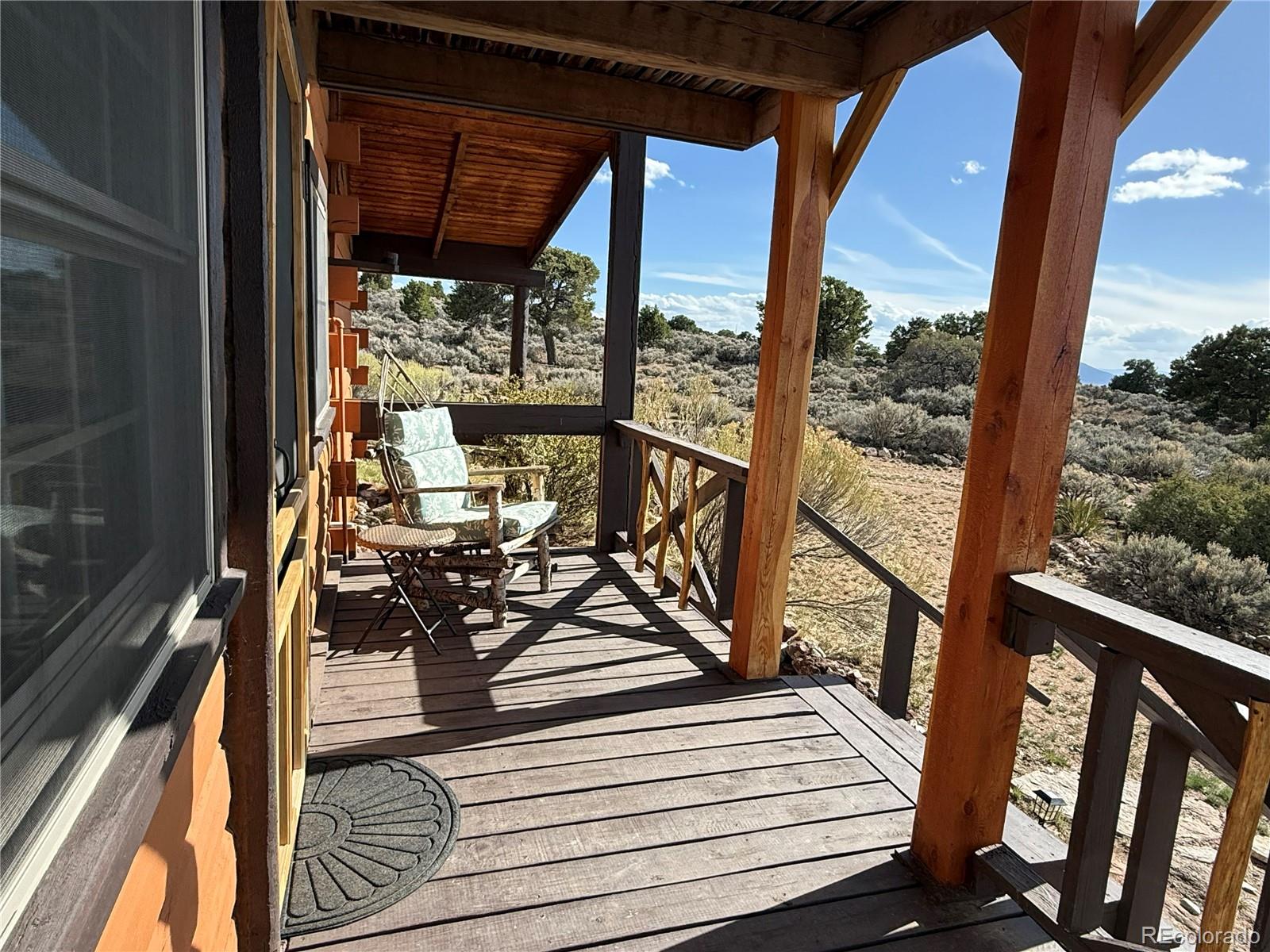 6132 Running Horse Road San Luis, CO 81152 - Photo 8 of 45 a view of a balcony with chairs and wooden floor