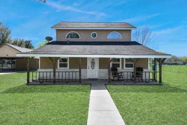 a view of a house with a yard and sitting area