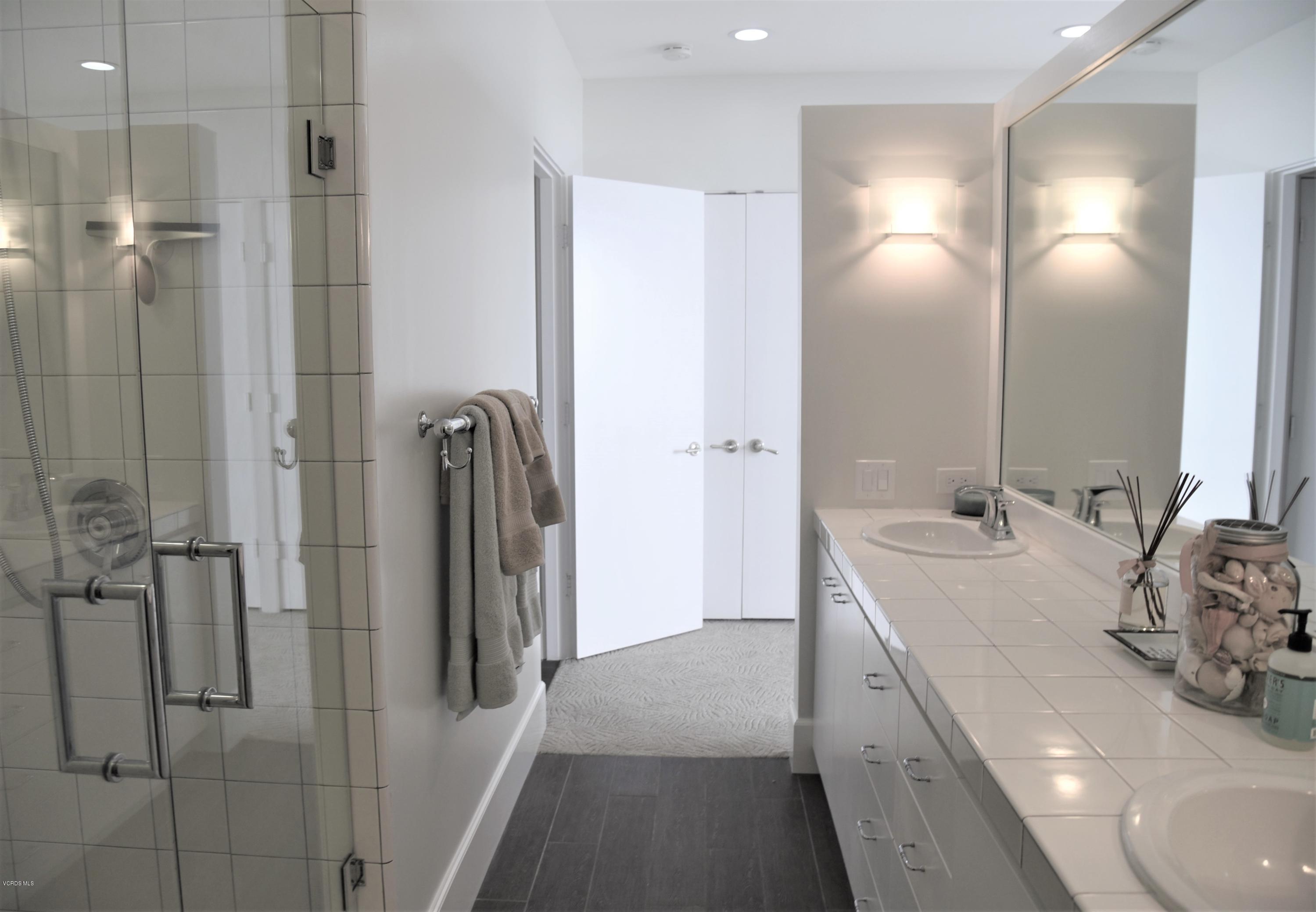 4885 Sandyland Road, Unit 2 Carpinteria, CA 93013 - Photo 21 of 39 a bathroom with a double vanity sink mirror and shower