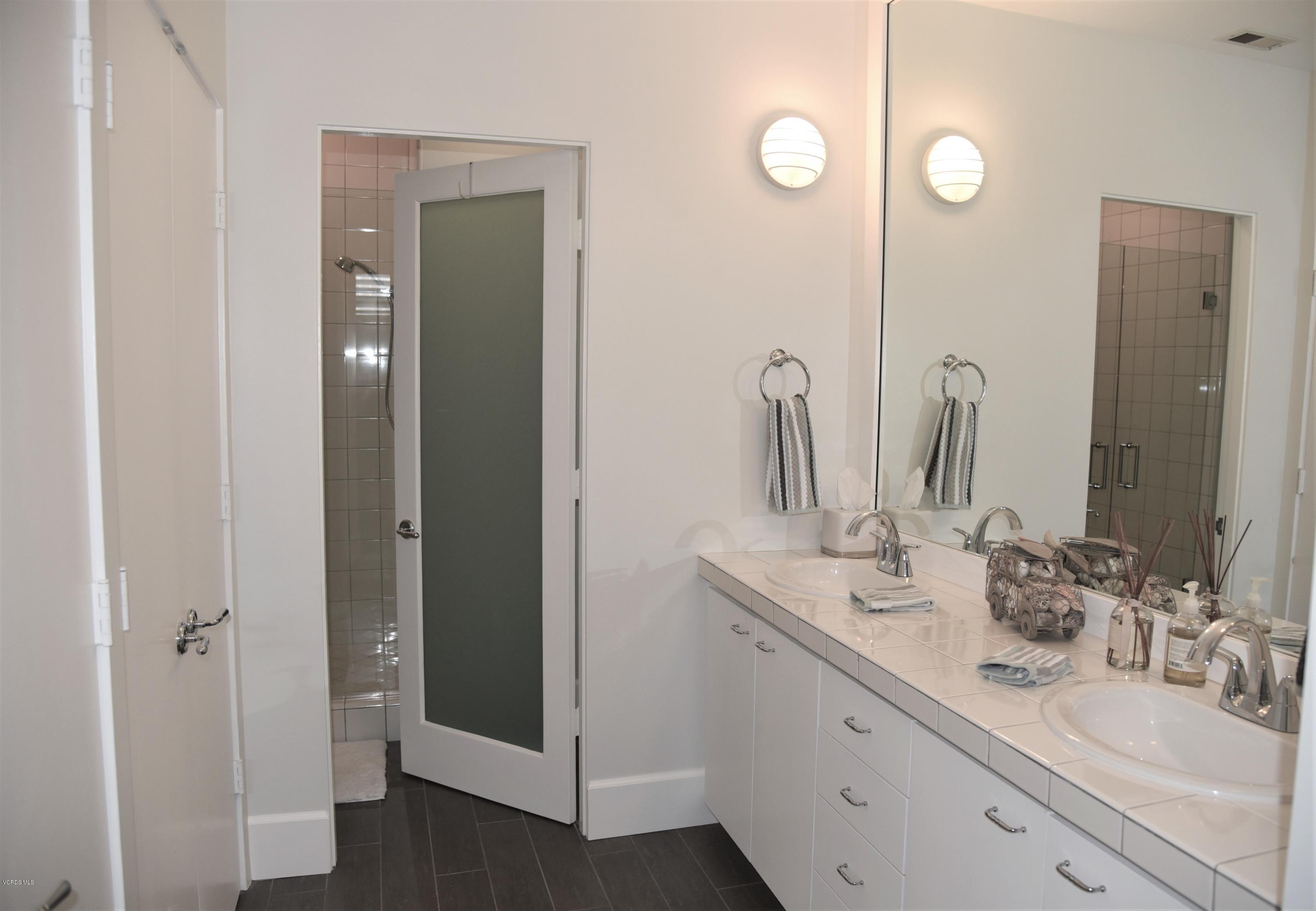 4885 Sandyland Road, Unit 2 Carpinteria, CA 93013 - Photo 24 of 39 a bathroom with double vanity sink and a mirror
