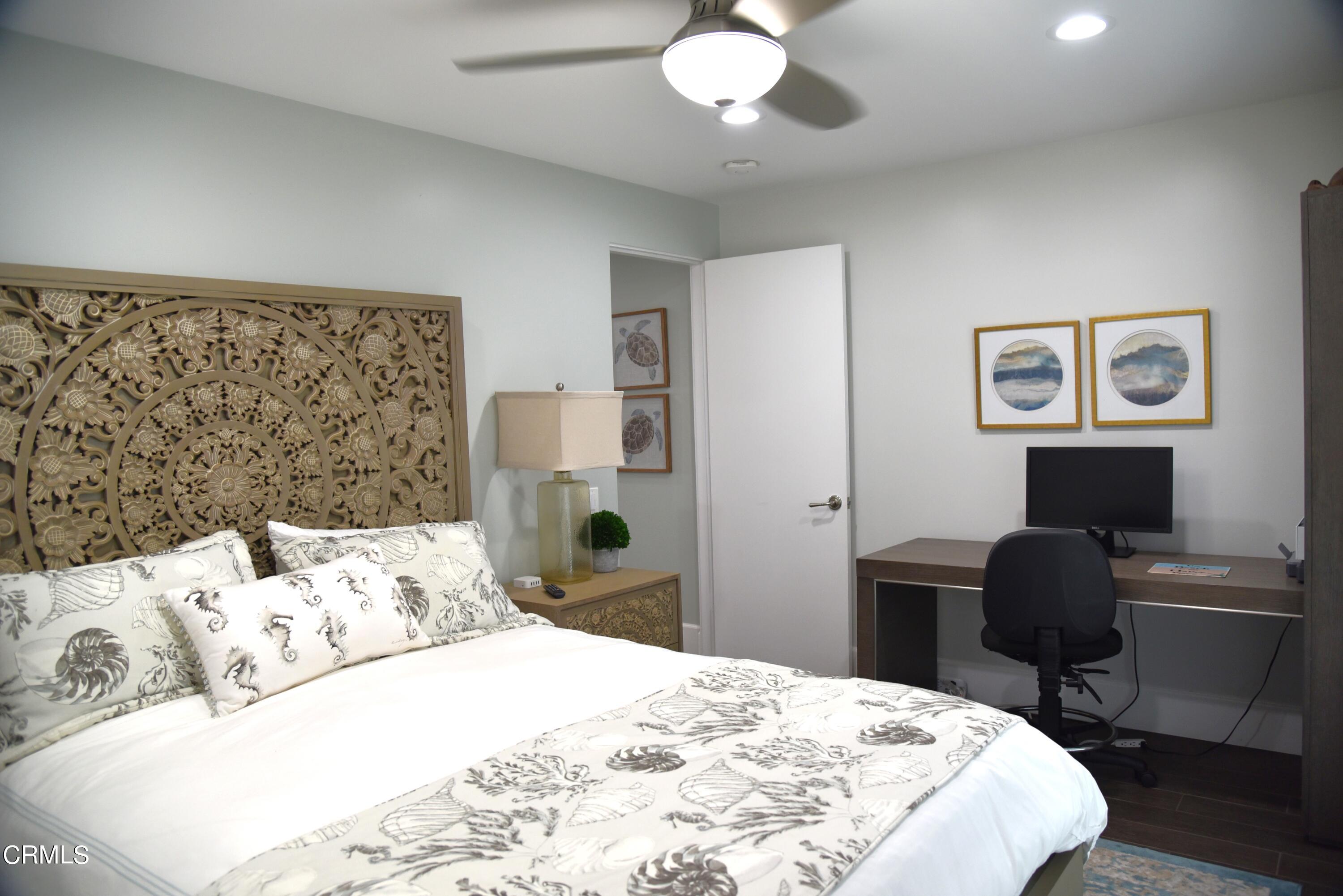 4885 Sandyland Road, Unit 2 Carpinteria, CA 93013 - Photo 26 of 39 a bedroom with a bed and a chandelier