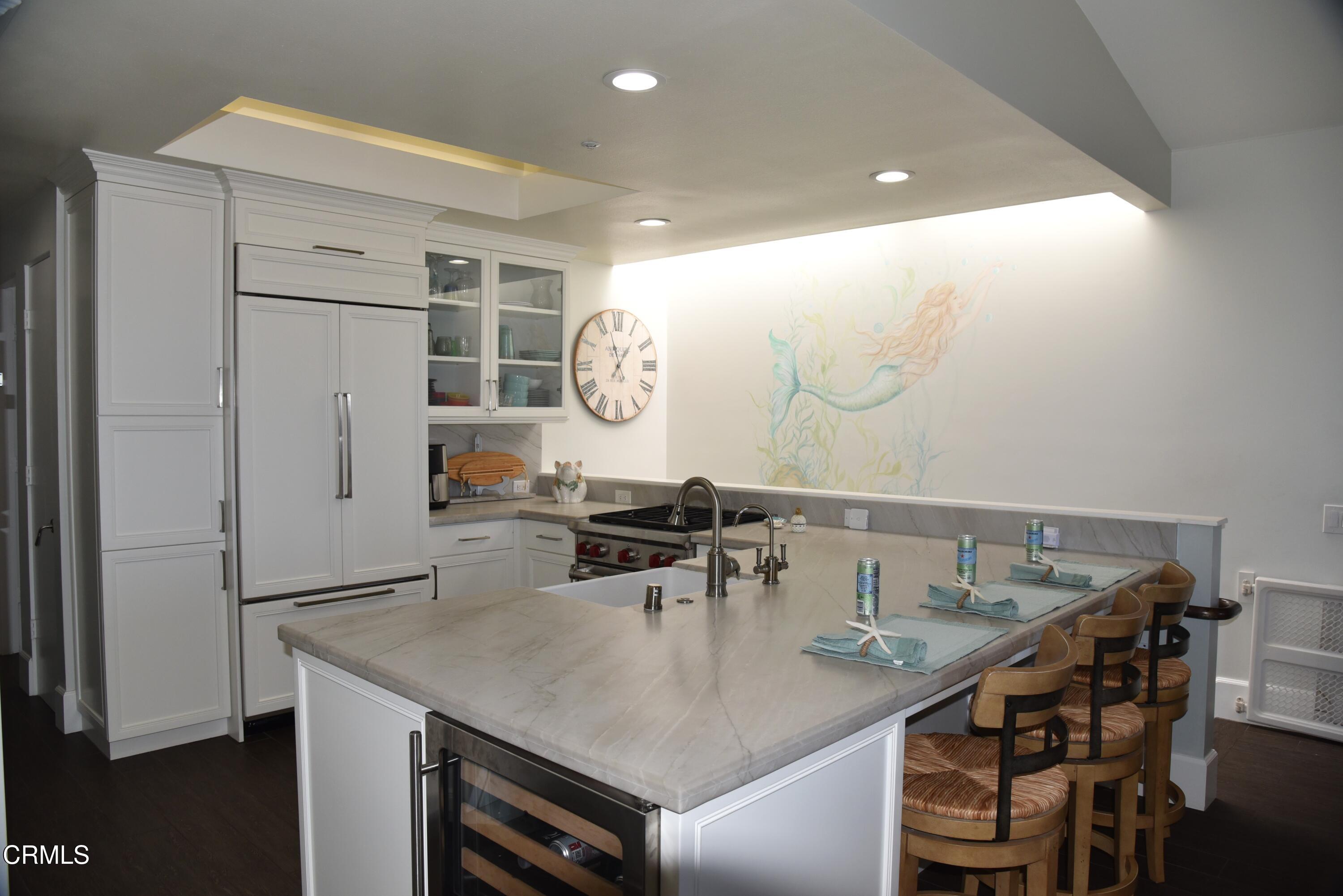 4885 Sandyland Road, Unit 2 Carpinteria, CA 93013 - Photo 10 of 39 a kitchen with a table chairs and a refrigerator