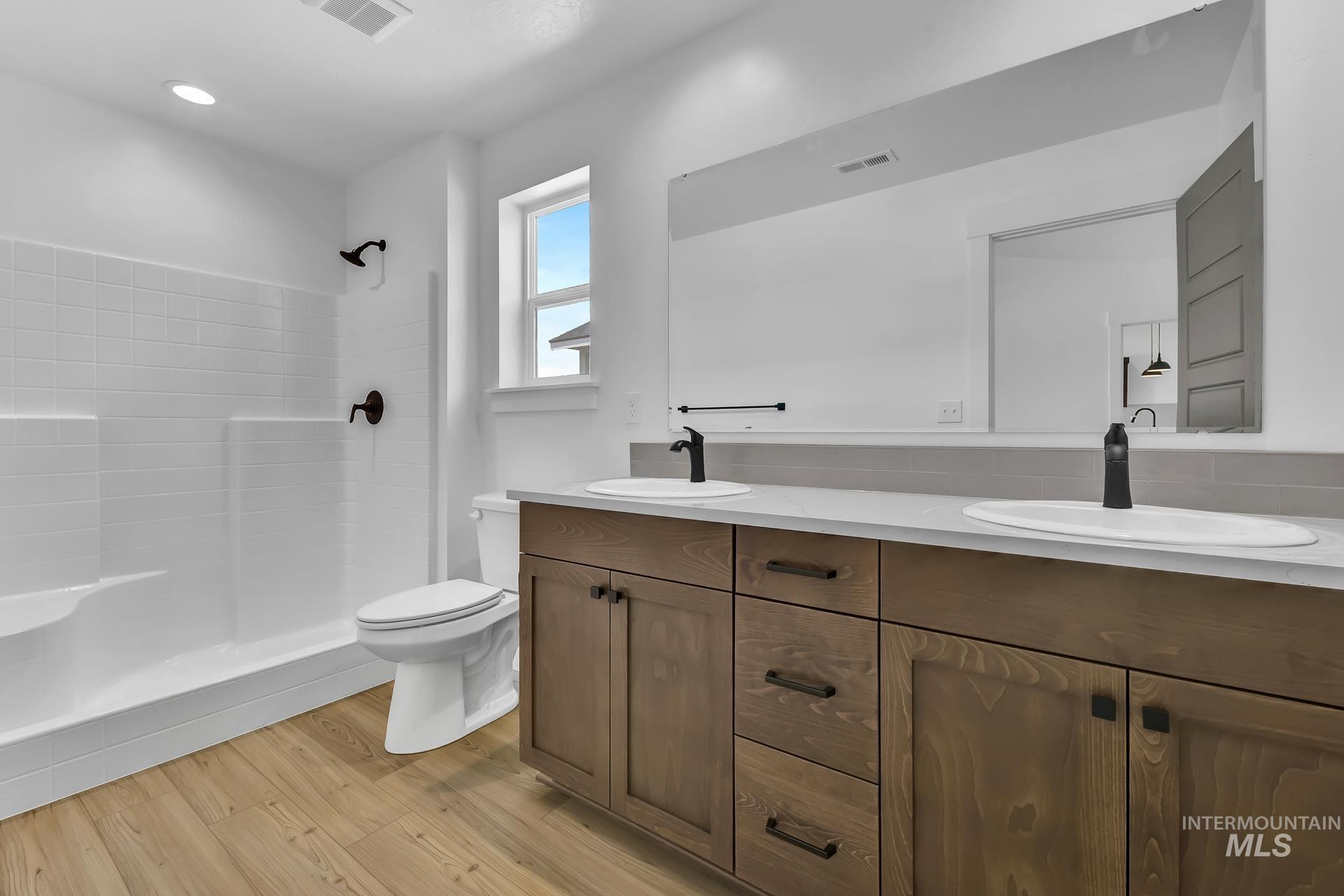 1160 Velvet Loop Wilder, ID 83676 - Photo 13 of 29 Full bath featuring double vanity, a tile shower, and light wood-style floors