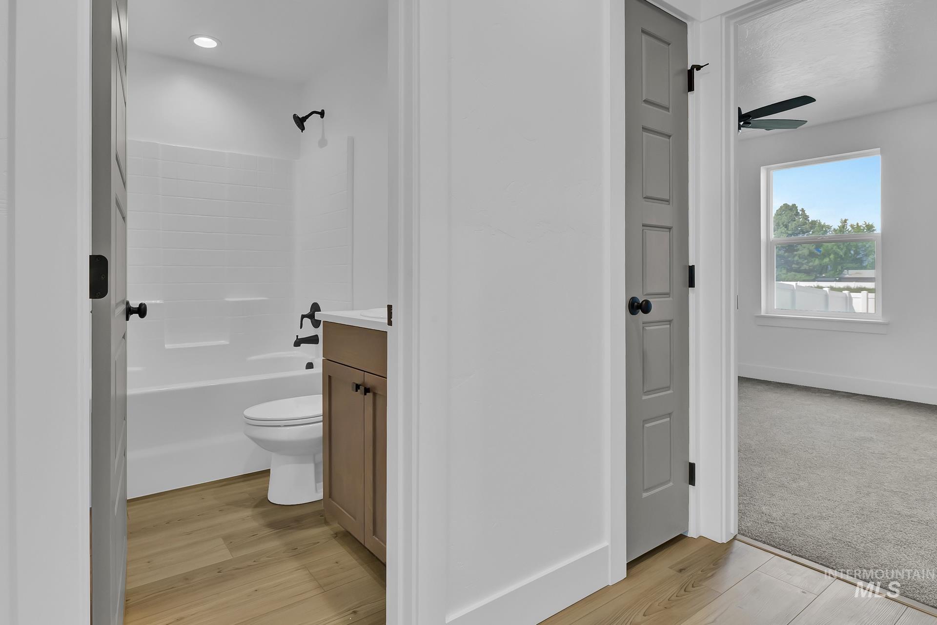 1160 Velvet Loop Wilder, ID 83676 - Photo 18 of 29 Full bath featuring vanity, light wood-type flooring, bathing tub / shower combination, and a ceiling fan