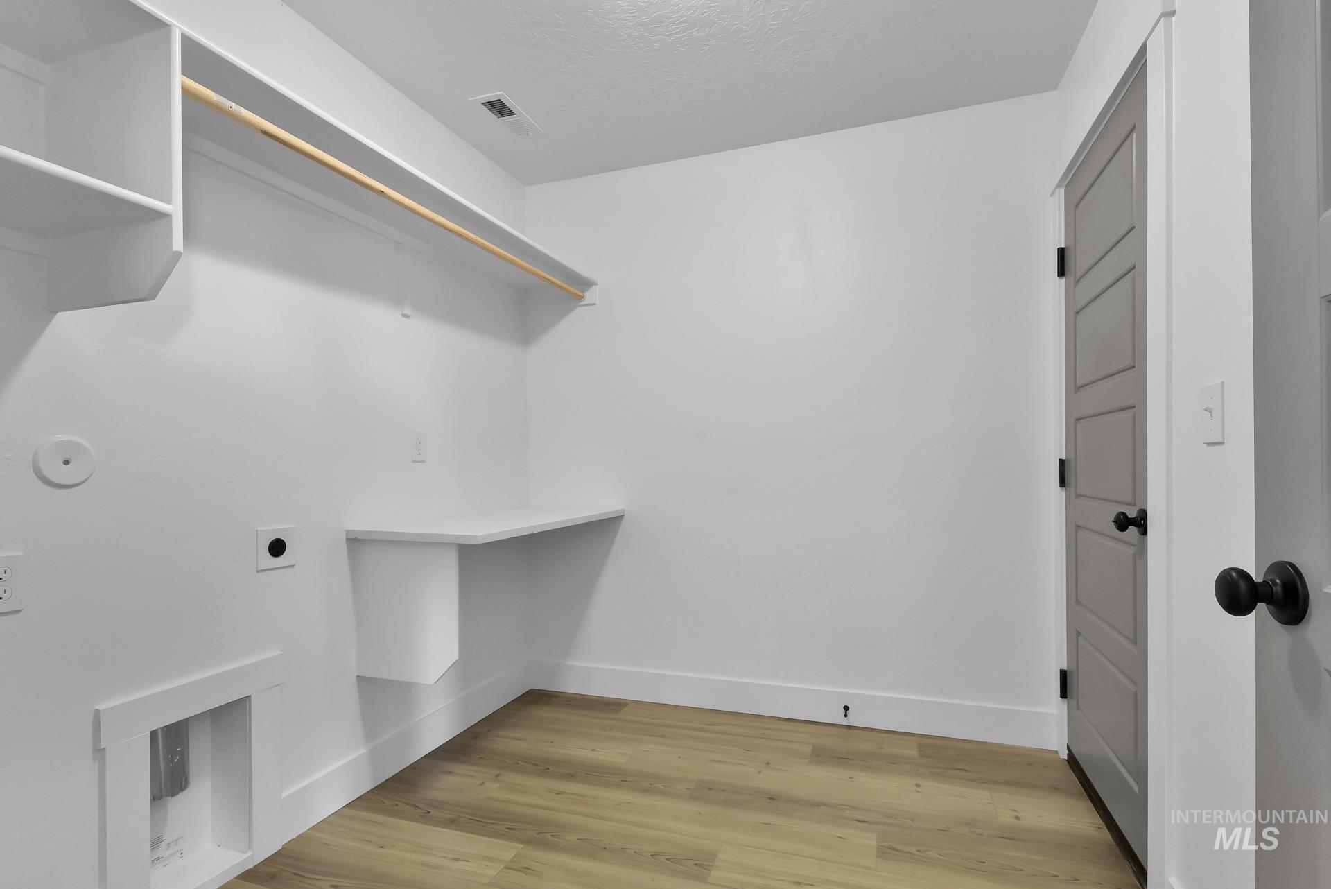 1160 Velvet Loop Wilder, ID 83676 - Photo 24 of 29 Washroom featuring light wood finished floors, hookup for an electric dryer, and a textured ceiling