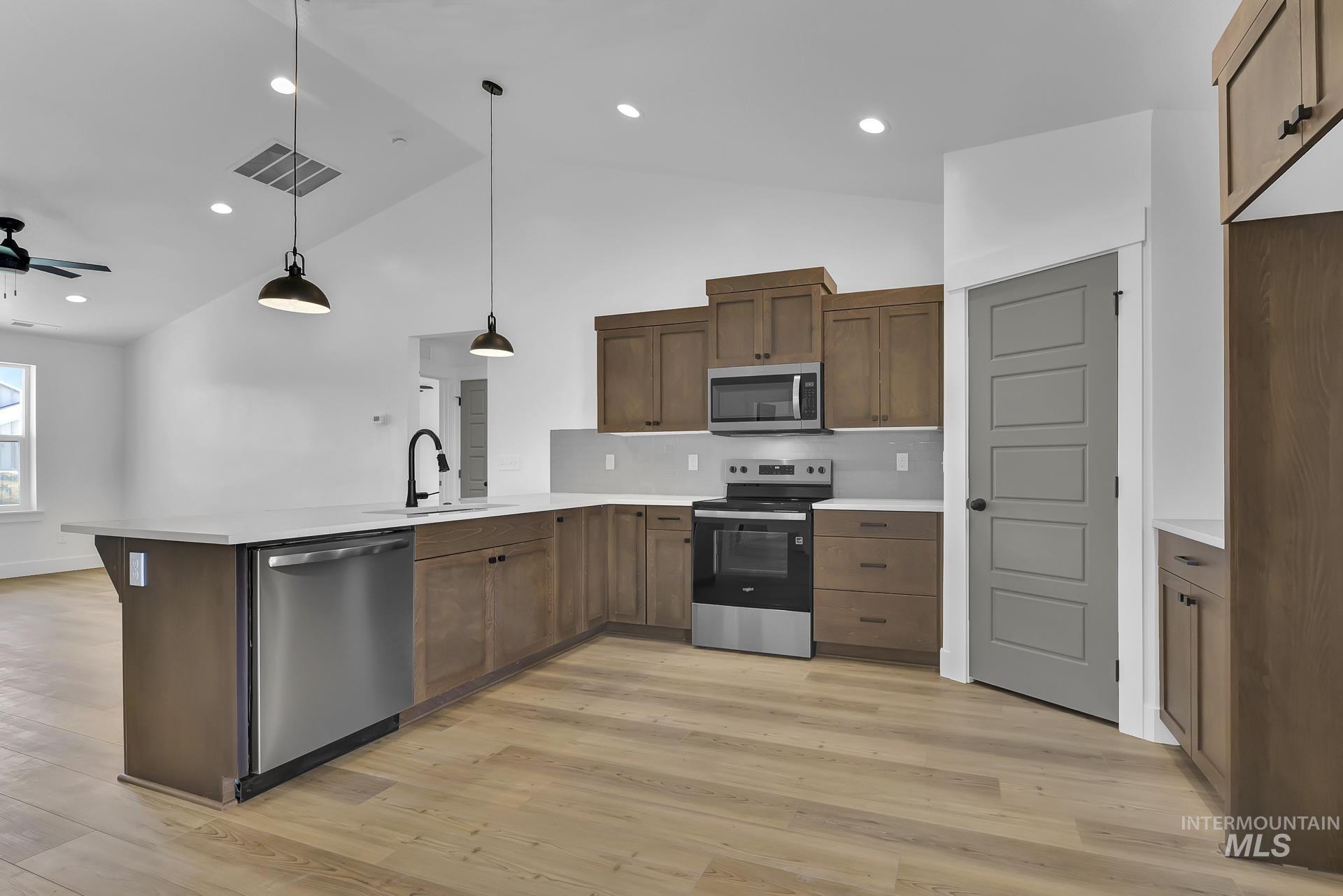1160 Velvet Loop Wilder, ID 83676 - Photo 6 of 29 Kitchen with stainless steel appliances, pendant lighting, a peninsula, high vaulted ceiling, and ceiling fan