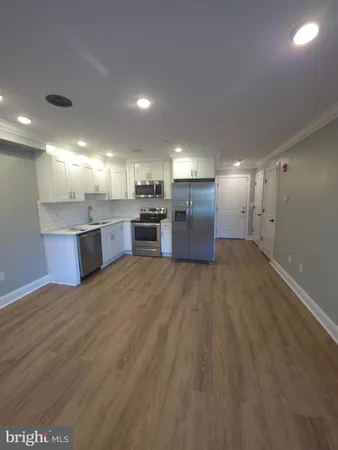 a view of a kitchen with a sink and a refrigerator