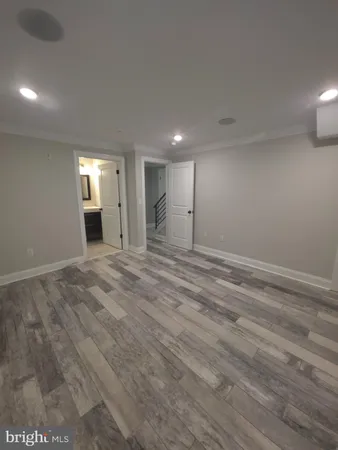 a view of a big room with wooden floor and windows