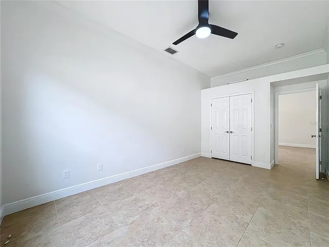 an empty room with windows and fan