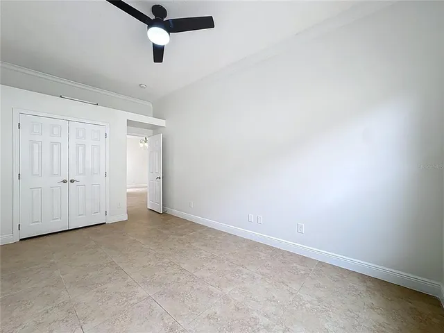 an empty room with chandelier fan