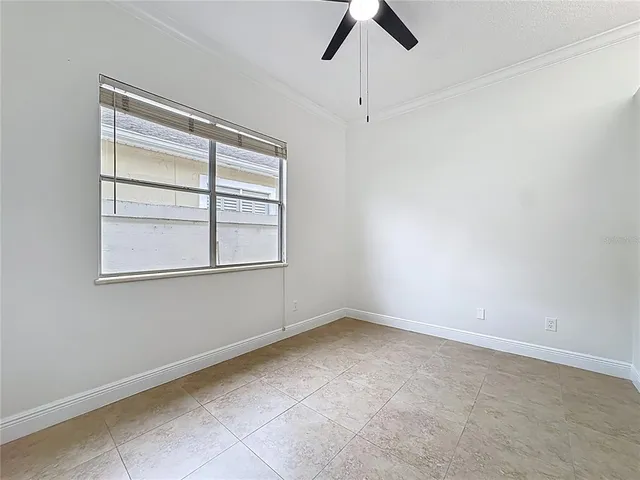 an empty room with a window and ceiling fan