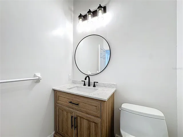 a view of an empty room with a chandelier fan