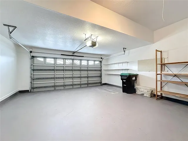 an aerial view of a house with swimming pool and large trees