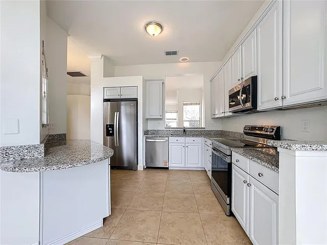 a kitchen with granite countertop a refrigerator and a sink