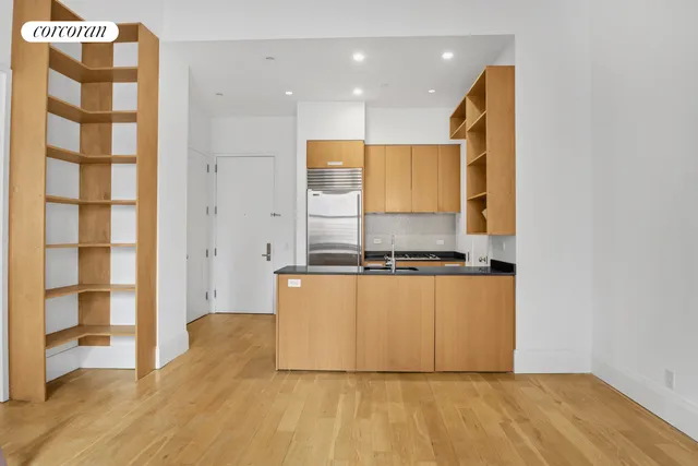 a kitchen with stainless steel appliances granite countertop a stove a sink and a refrigerator with wooden floor