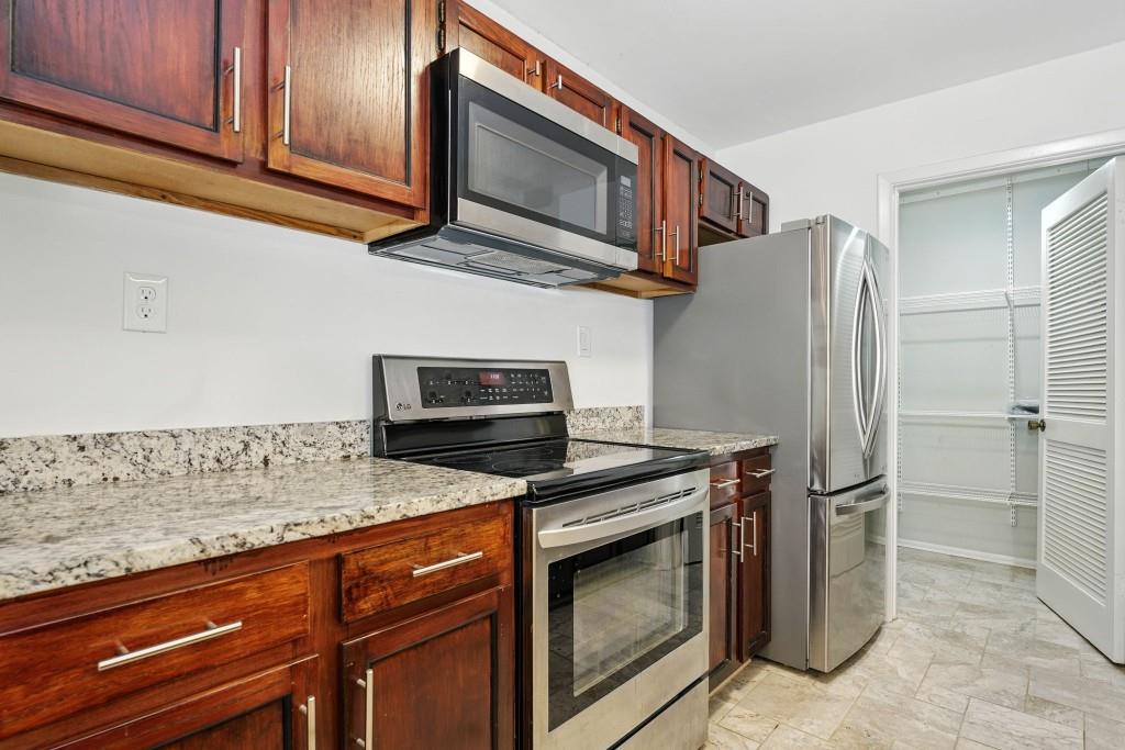 217 Tuxworth Circle Decatur, GA 30033 - Photo 6 of 38 a kitchen with stainless steel appliances granite countertop a refrigerator microwave and stove top oven