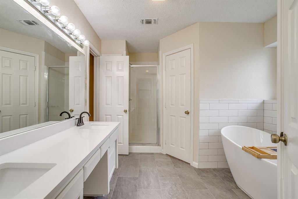 8613 Silver Creek Road White Settlement, TX 76108 - Photo 17 of 40 a bathroom with a tub a sink and a large mirror