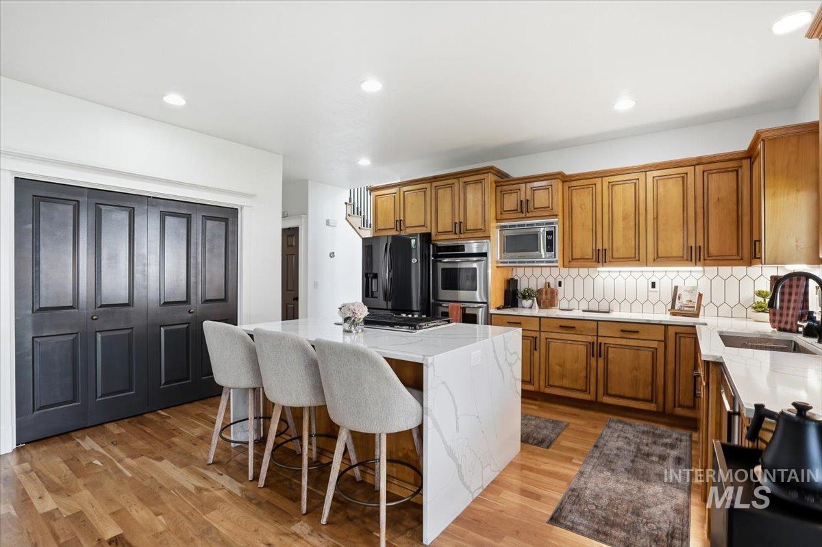 342 North Clearpoint Way Eagle, ID 83616 - Photo 12 of 50 Kitchen featuring wood finish cabinetry, a center island, light stone countertops, and recessed lighting