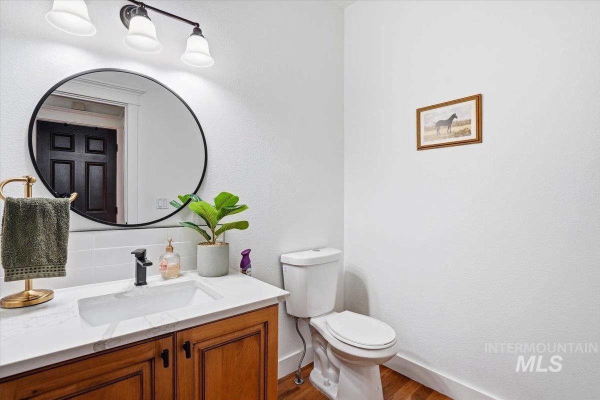 342 North Clearpoint Way Eagle, ID 83616 - Photo 25 of 50 Half bath featuring vanity, tasteful backsplash, and wood finished floors