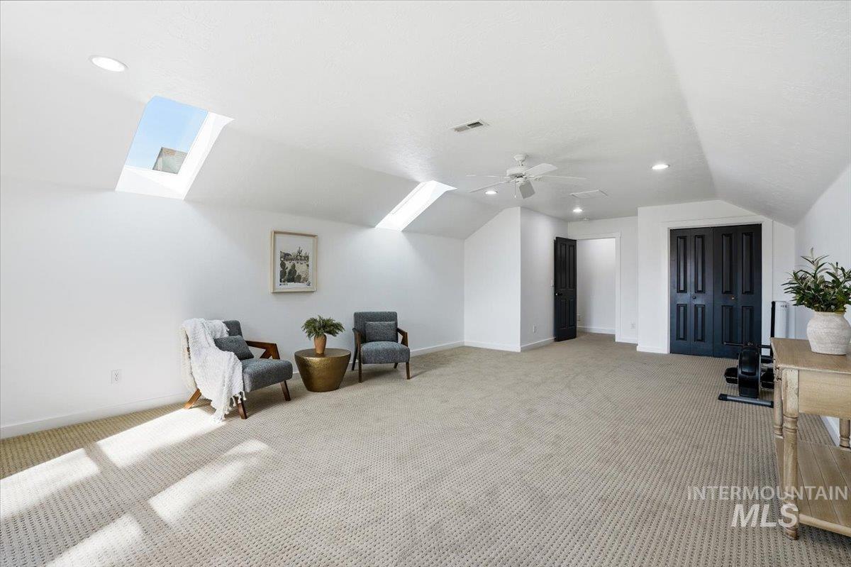 342 North Clearpoint Way Eagle, ID 83616 - Photo 37 of 50 Sitting room with a skylight, lofted ceiling, light carpet, a ceiling fan, and recessed lighting
