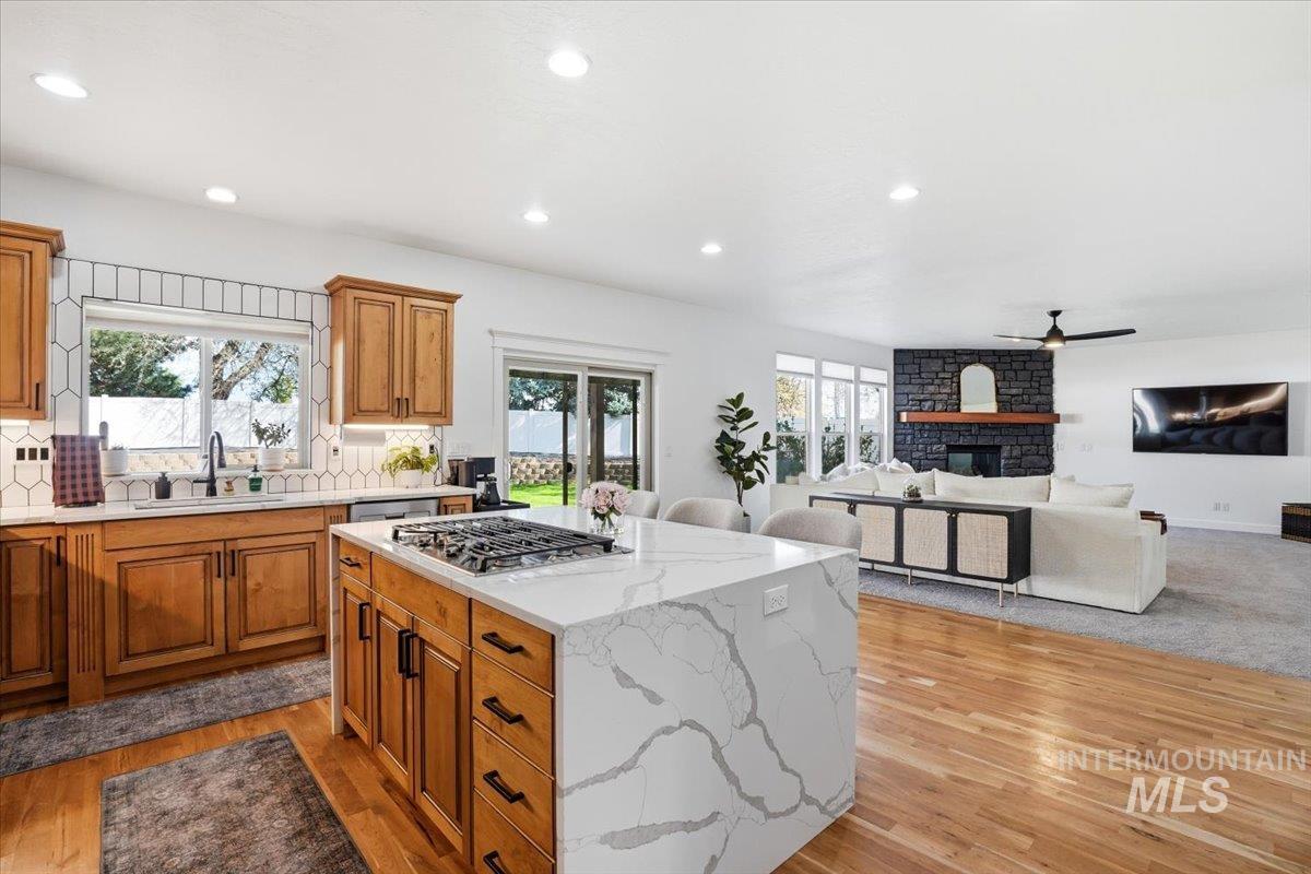 342 North Clearpoint Way Eagle, ID 83616 - Photo 10 of 50 Kitchen featuring a kitchen island, wood finish cabinetry, light wood-type flooring, light stone countertops, and recessed lighting