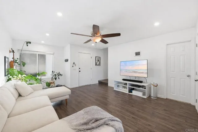 a living room with furniture a ceiling fan and a window