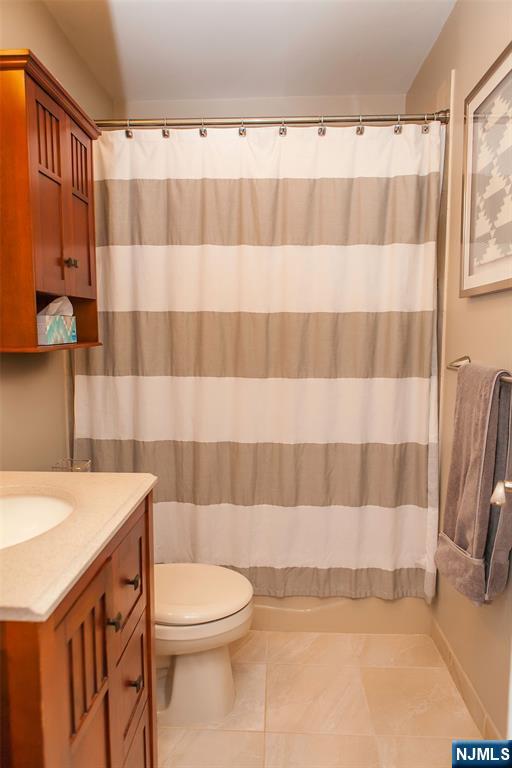 309 1st Street, Unit 3C Hoboken, NJ 07030 - Photo 12 of 13 a bathroom with a sink a toilet a mirror and shower curtain