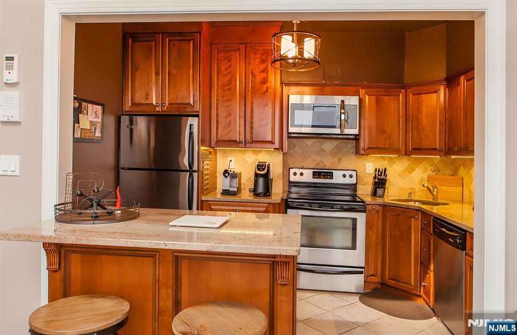 309 1st Street, Unit 3C Hoboken, NJ 07030 - Photo 4 of 13 a kitchen with stainless steel appliances granite countertop a stove and a refrigerator