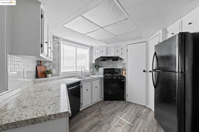 a kitchen with granite countertop a refrigerator stove and sink