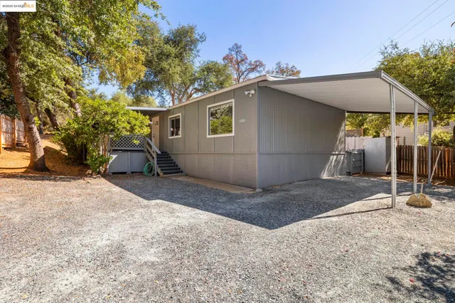 a backyard of a house with barbeque oven table and chairs