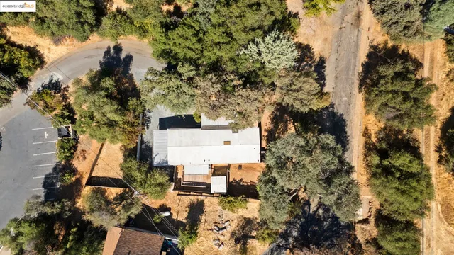 an aerial view of residential houses with outdoor space and trees