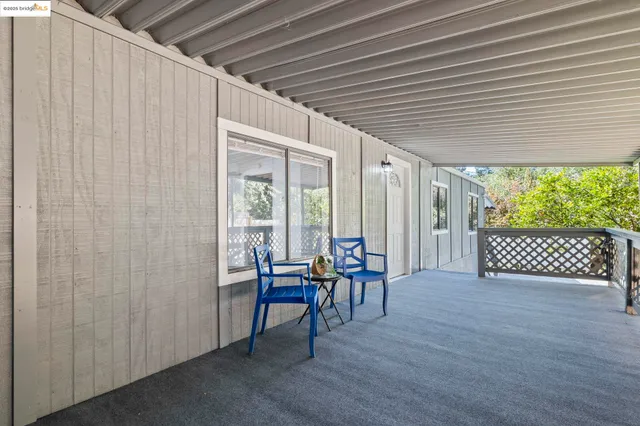 a view of a patio with table and chairs with wooden floor and fence