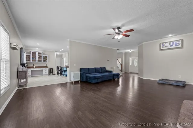 a living room with furniture and wooden floor