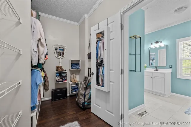a view of walk in closet with clothes and shoes