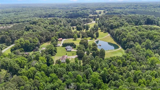an aerial view of residential house with outdoor space and trees all around