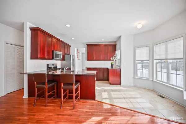 a living room with stainless steel appliances granite countertop furniture wooden floor and a window