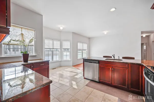 a large kitchen with stainless steel appliances granite countertop a sink and cabinets